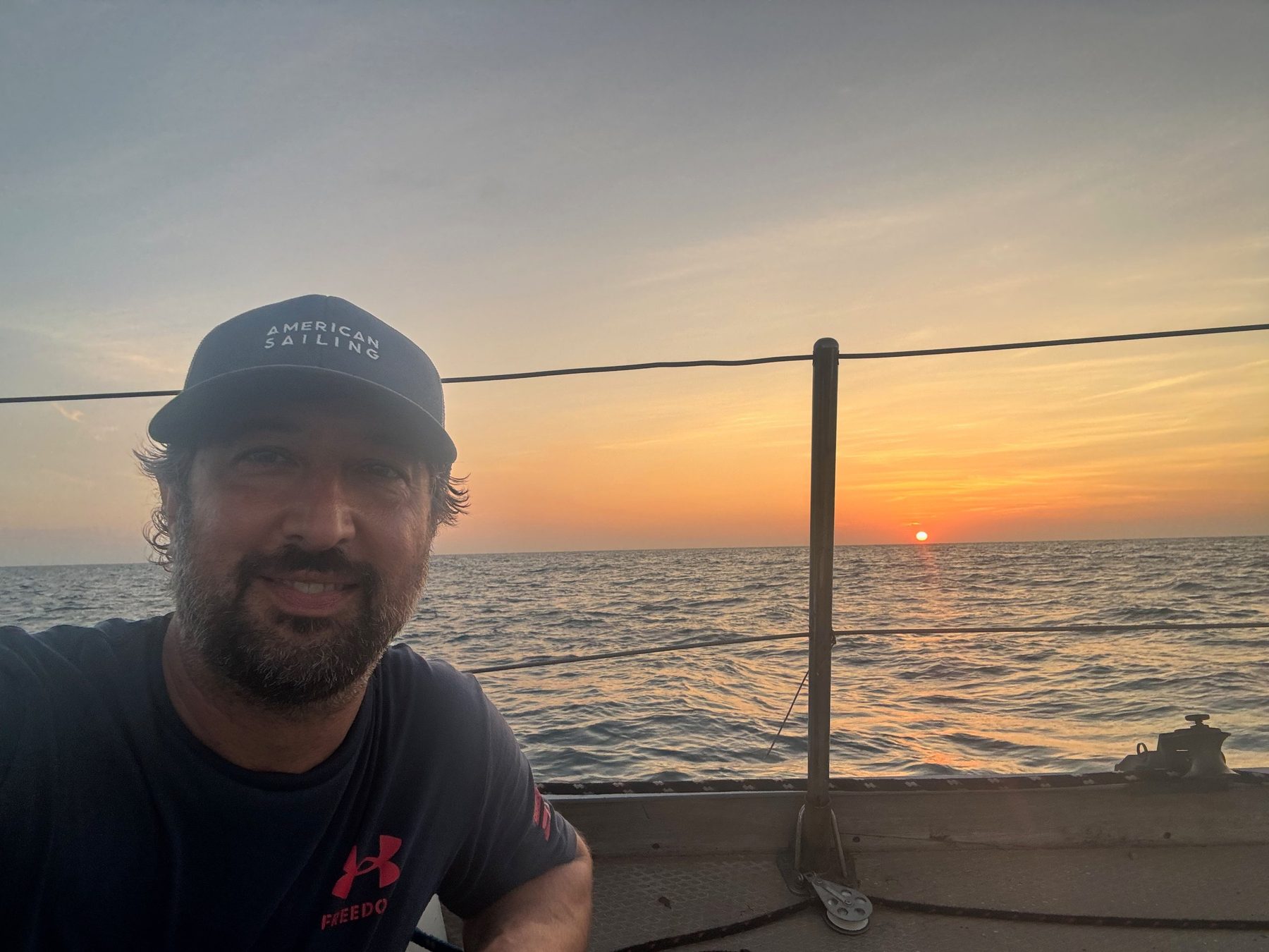 Your captain at the rail as the sun sets over open water