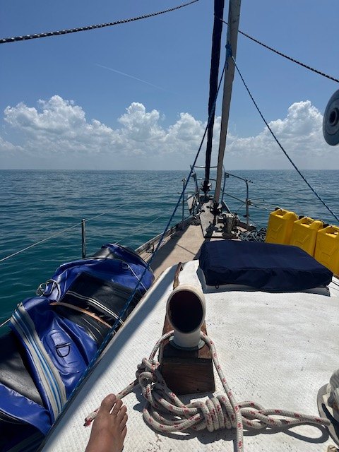 Yemaya's foredeck under a blue sky with clear water all around