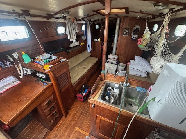Down below on Yemaya: a nav desk, galley sink, and teak sole