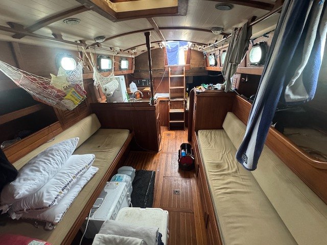 Yemaya's main saloon with teak joinery, long settees, and round portlights