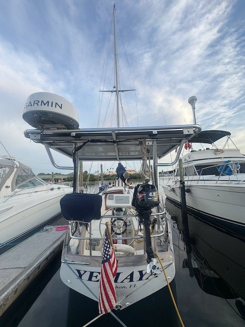 Yemaya's stern at the dock showing her name, an American flag, and the radar arch over the cockpit